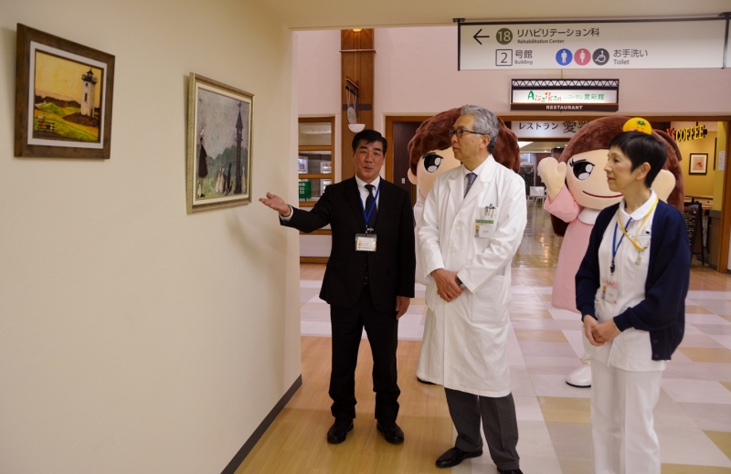 山村理事長から絵画の説明を聴く三浦病院長と田渕看護部長