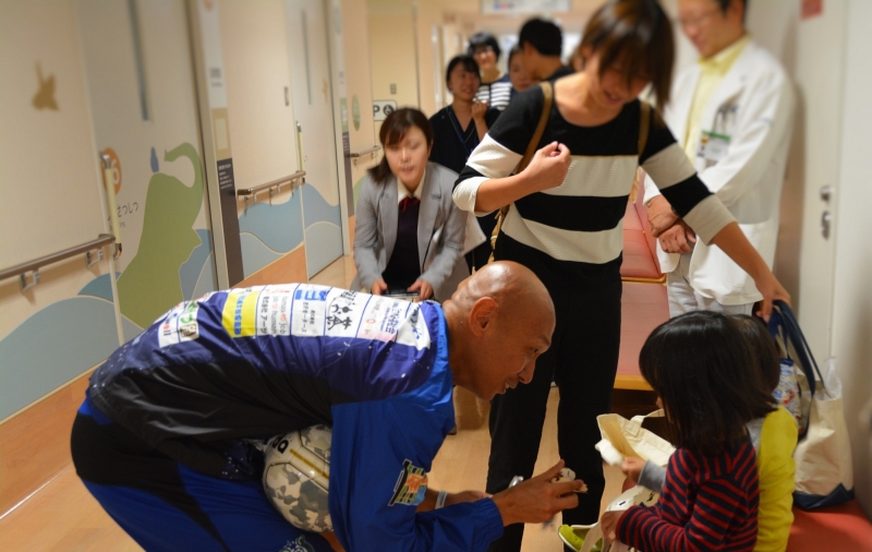 診療中の子どもと触れ合う久光選手