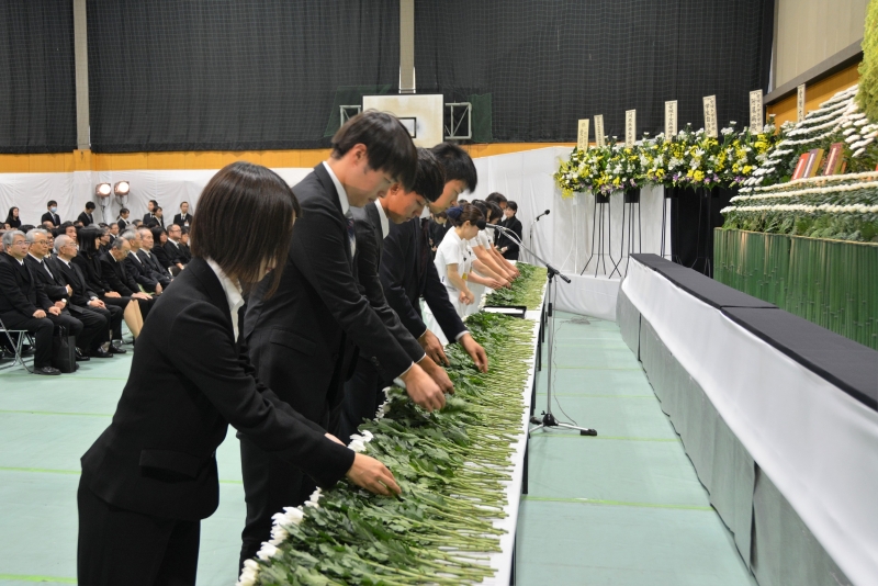 白菊を献花する教職員・学生